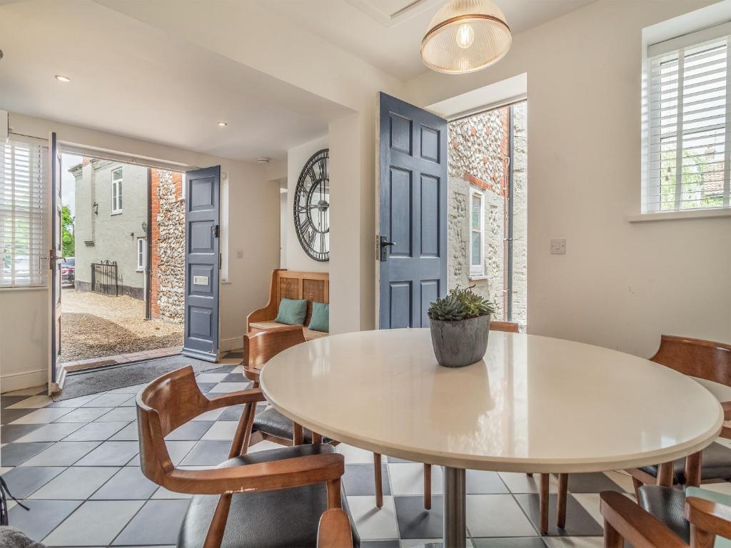 The round dining table beside the blue front door