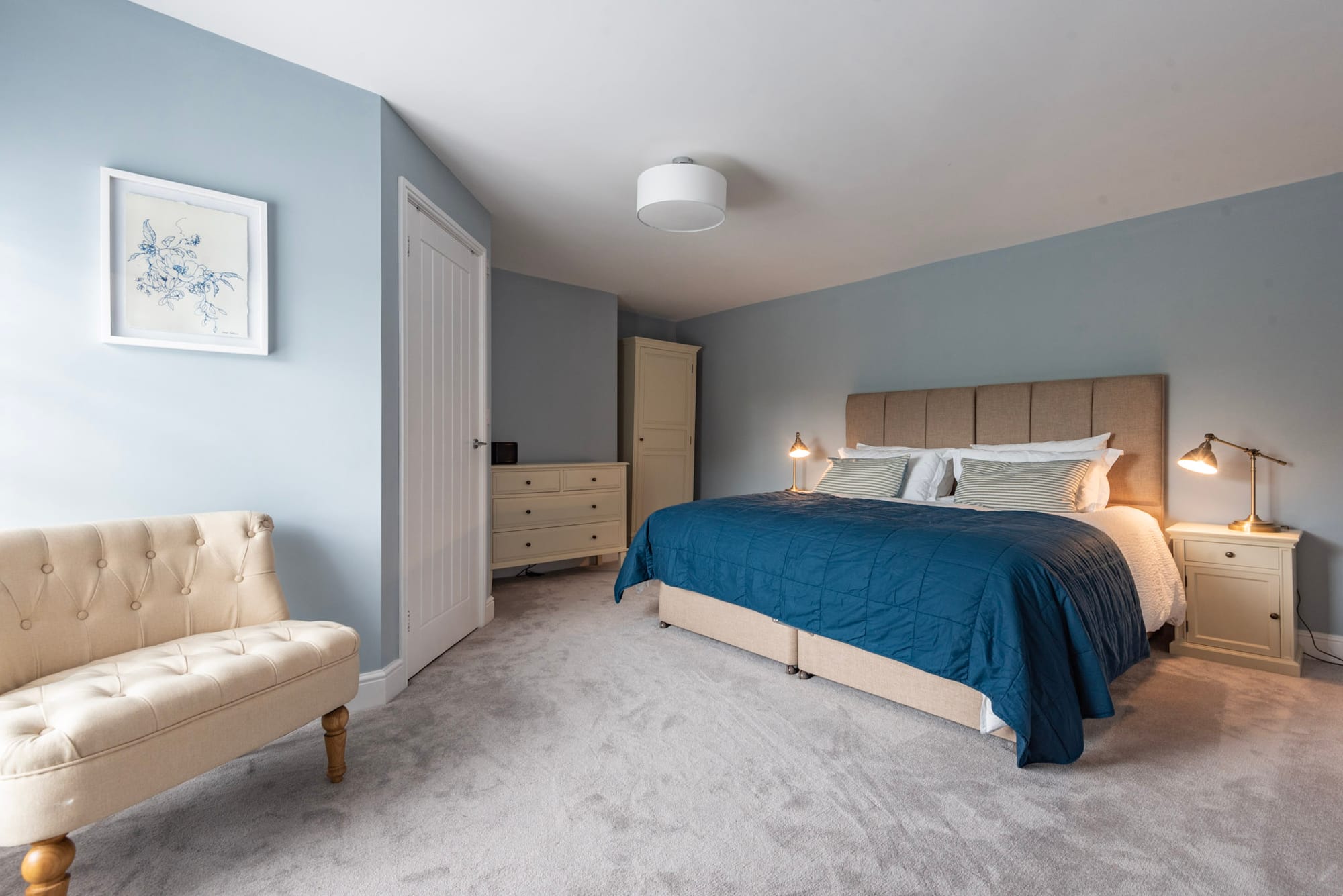 The Brancaster Room at South Creek Retreat, its bed against the blue wall